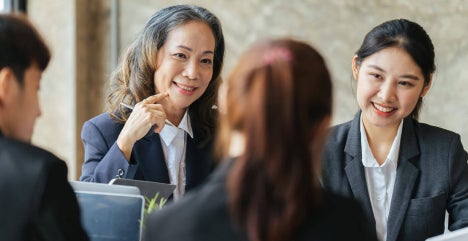 Senior manager leading a discussion with a seated team.